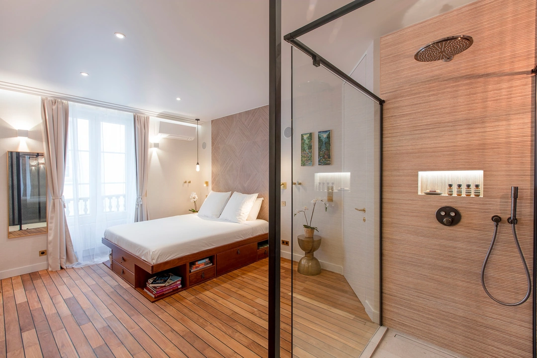 Vue de la chambre et de la très grande douche à l’italienne derrière la verrière