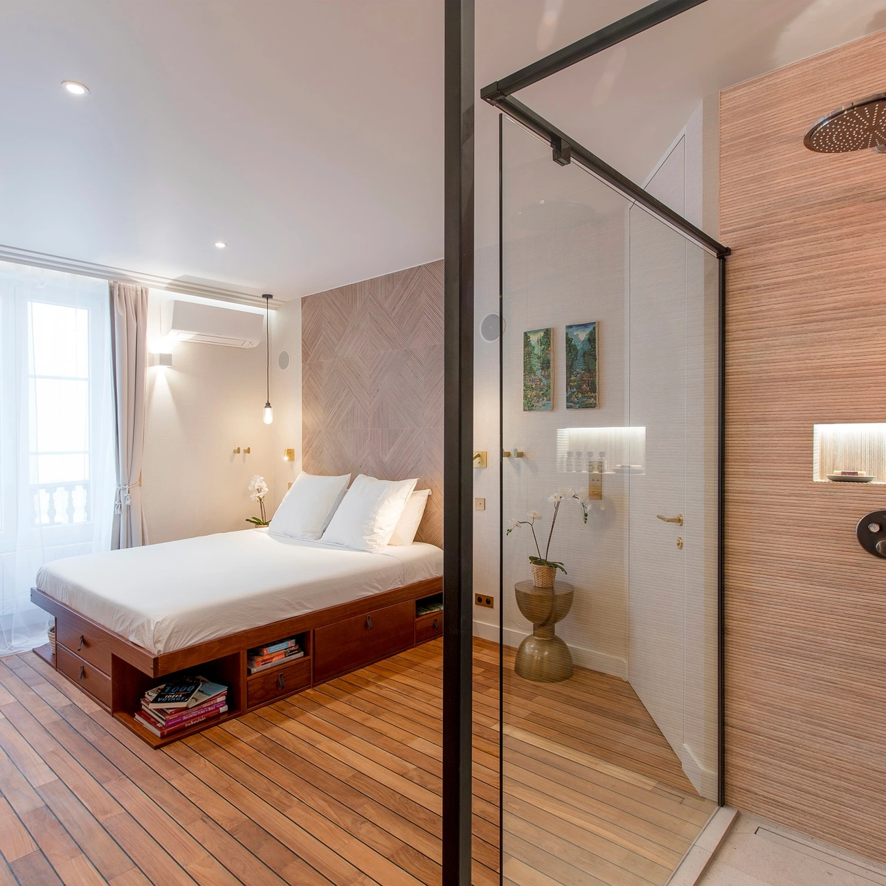 View of the bedroom and the spacious walk-in shower behind the glass enclosure
