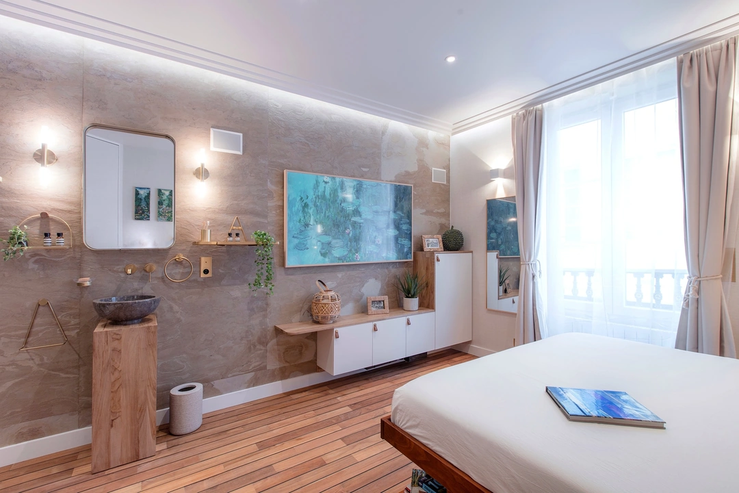 Chambre avec parquet en teck, vasque en pierre et appliques en laiton