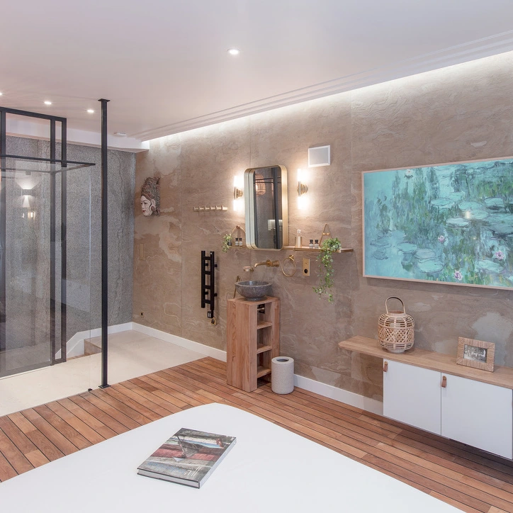 Vista del dormitorio, la mampara de cristal de la ducha y el cuadro sobre el mueble.