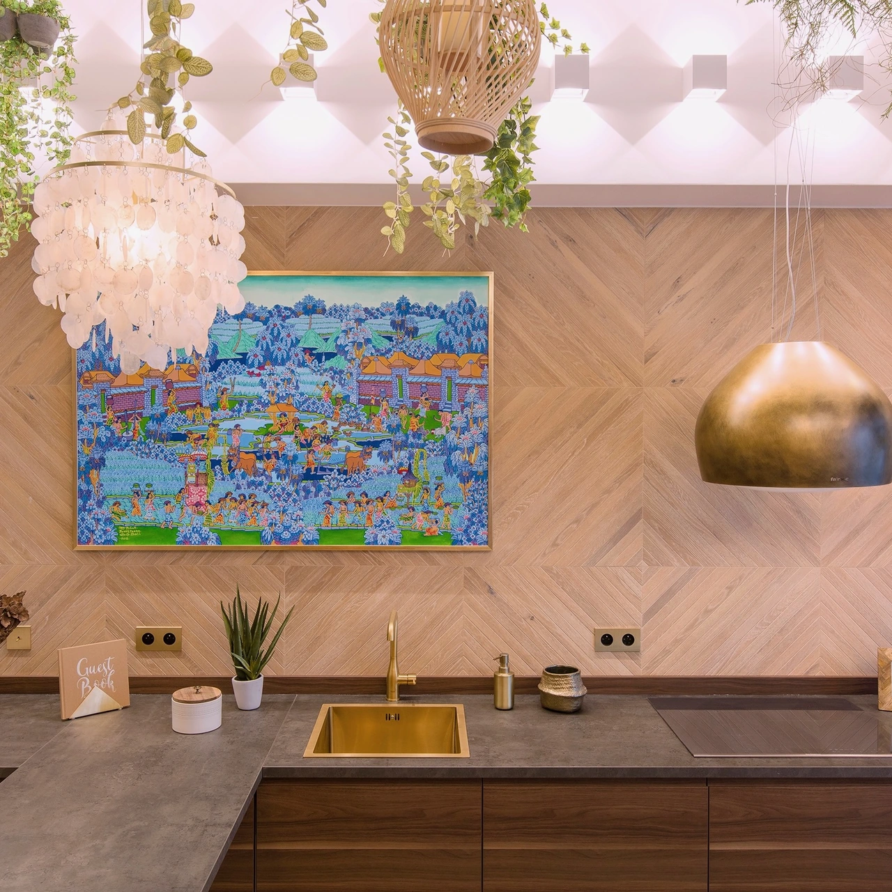 Equipped kitchen with a brass pendant light and Balinese painting