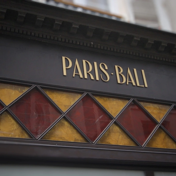 La inscripción Paris Bali sobre un panel decorativo de motivos de colores.