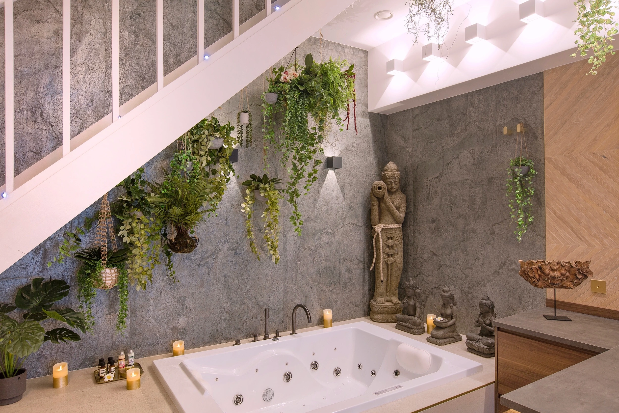 Jacuzzi privatif deux places entouré de plantes et de sculptures balinaises