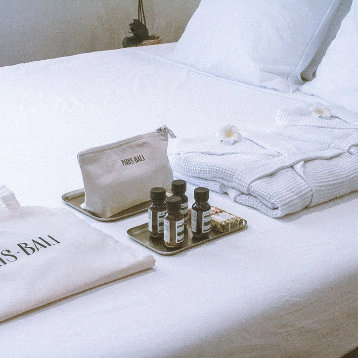 Albornoces, un neceser Paris Bali y productos de aseo sobre la cama.