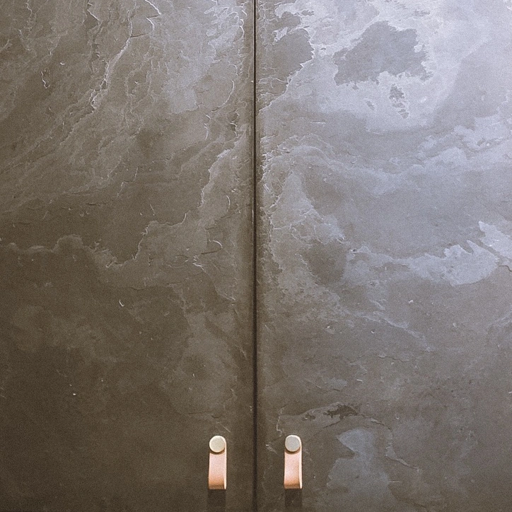 Puertas revestidas de láminas de piedra natural con tiradores.