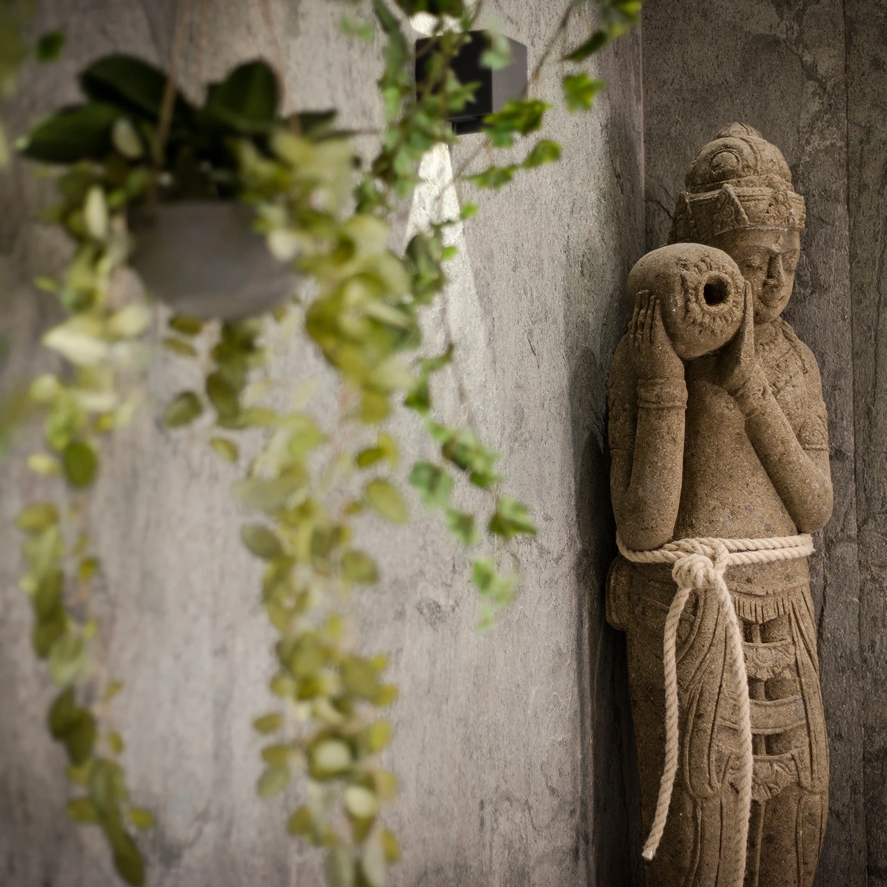 Large Balinese sculpture against the natural stone wall