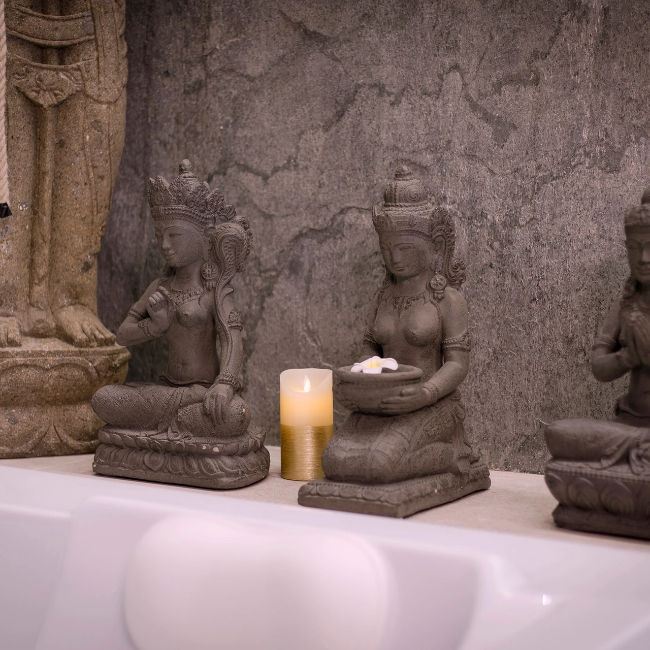 Small Balinese sculptures lined up by the jacuzzi
