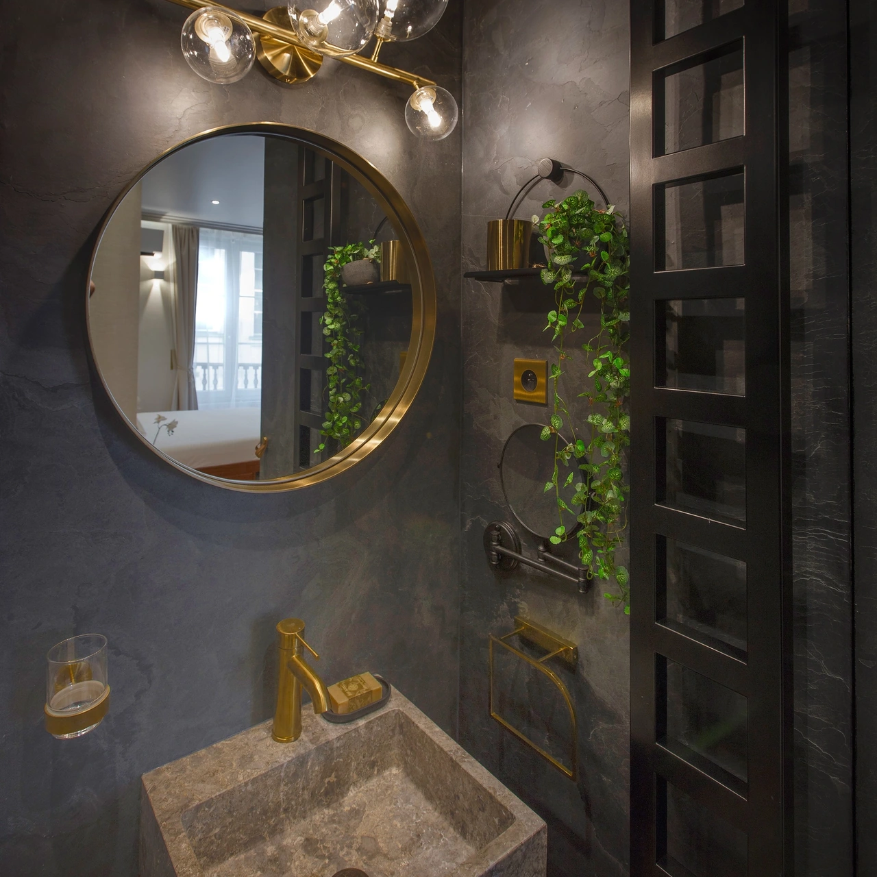 Stone basin, round mirror and golden taps